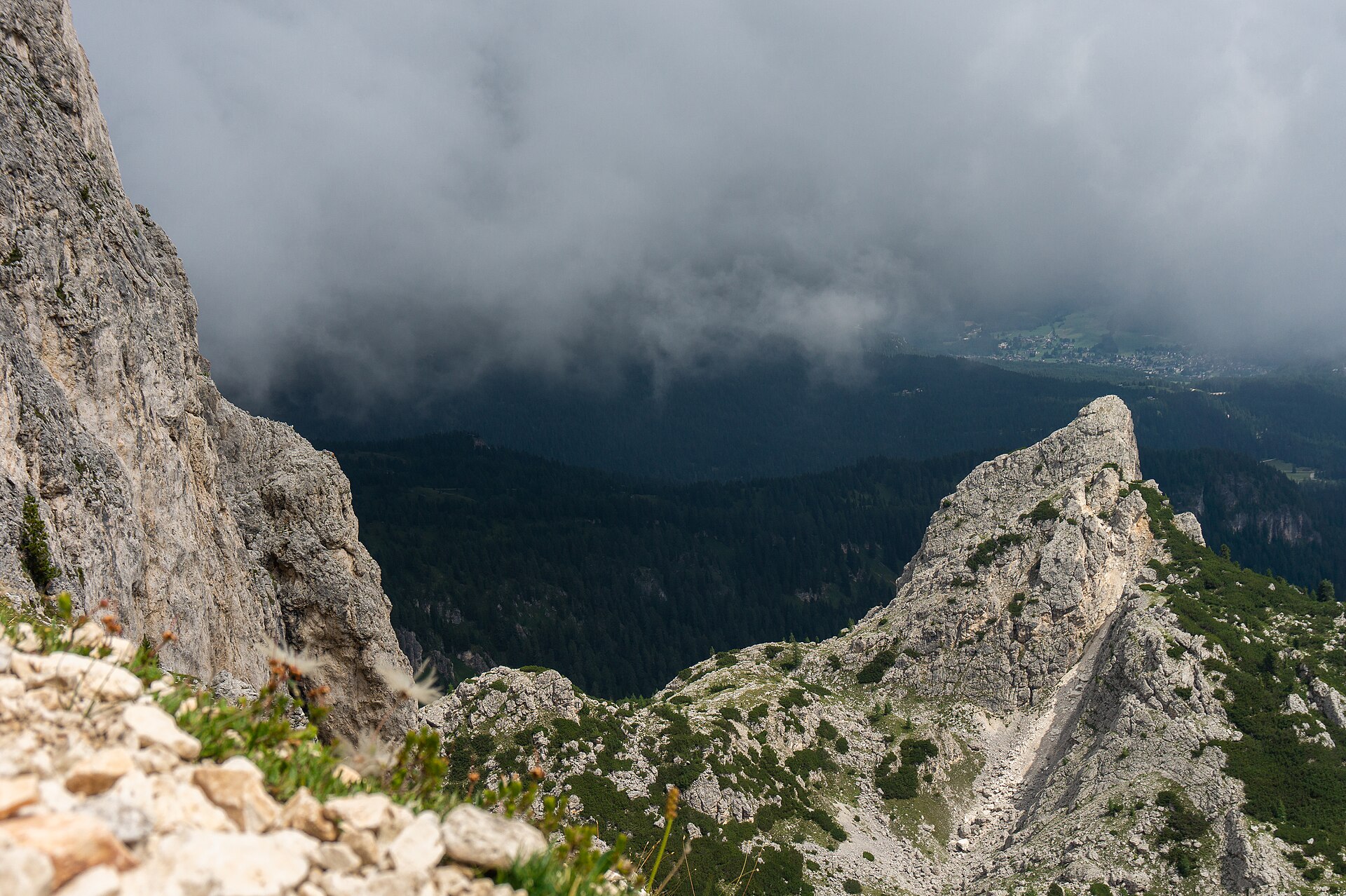 Hikers on the rocky trail between Forcella Nuvolau and Nuvolau refuge in the Dolomites.