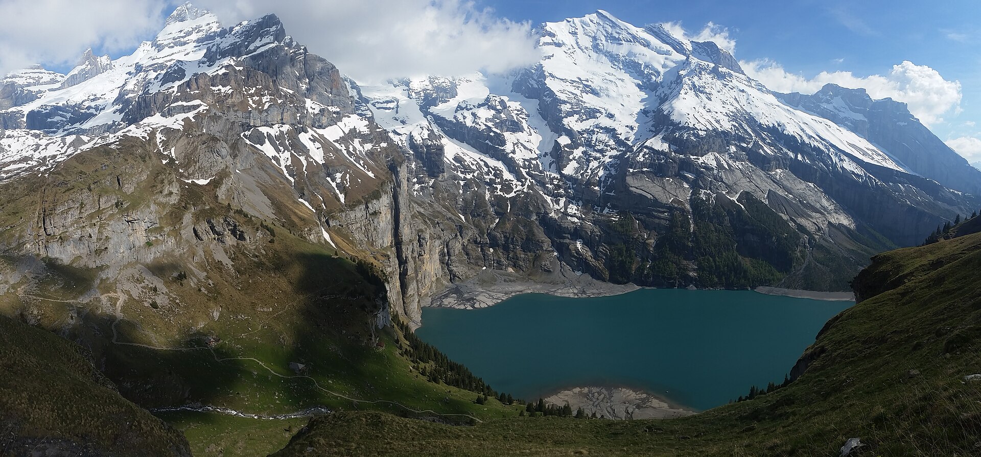 Turquoise Oeschinensee below the cliffs and glaciers above Kandersteg in summer.