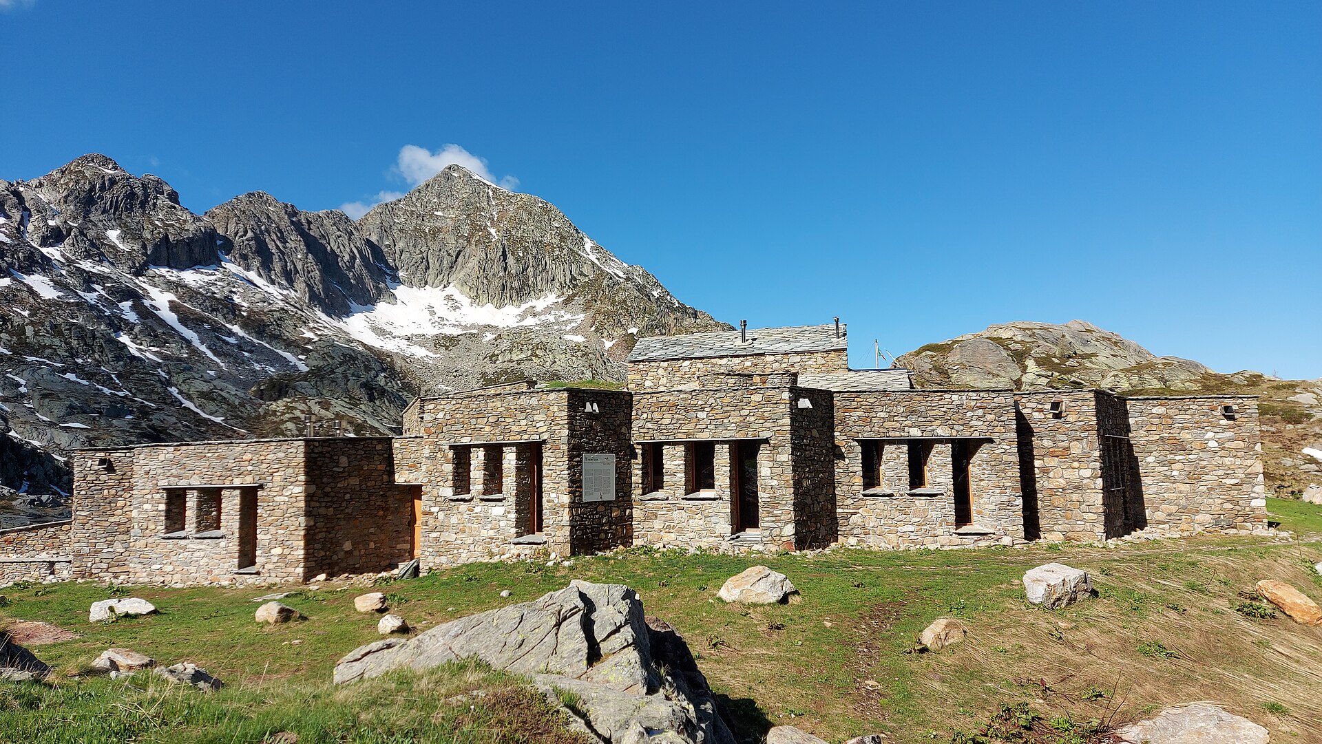 Stone Rifugio Barma beside alpine lakes below Monte Mars in the Aosta Valley.